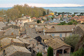 Fototapeta na wymiar Panoramic aerial view of the old famous city of Bolsena and Lake Bolsena at sunset. Province of Viterbo, Italy, Lazio. Cityscape and tiled roofs