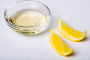 Lemon juice in a bowl. Essence. Lemon slices. White background.