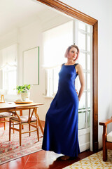 young beautiful lady wearing a blue dress posing in the living room