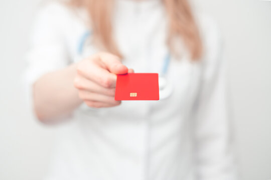 doctor holds a credit card in his hand. concept of paid and expensive medicine.