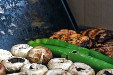 Chicken, mushrooms and peppers over the barbecue.