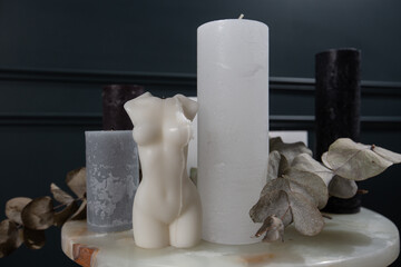 Beautiful body shaped candles on table indoors. Spa composition. Candles, eucalyptus on dark background. Flat lay, mock up. top view