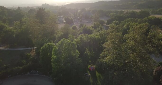 Drone pullback over mountainside farm in Yucaipa with lens flare