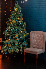 Obraz premium Closeup of Festively Decorated Outdoor Christmas tree with blue and golden balls on blurred sparkling fairy background. Defocused garland lights