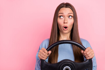 Fototapeta na wymiar Portrait of attractive amazed girl holding steering wheel thinking copy space wow adventure isolated over pink pastel color background
