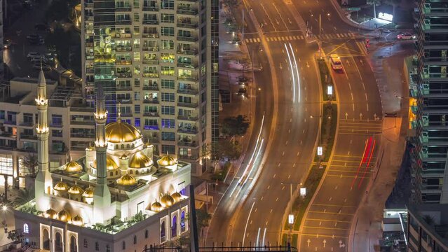Aerial view of the small mosque of Dubai Marina illuminated by night timelapse