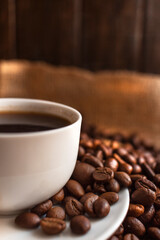 White porcelain espresso coffee cup with saucer on brown background.