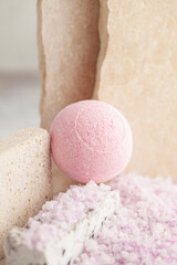Sea colored salt and bath ball on a stone podium. Spa cosmetics concept