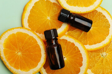 Essential oils in dark glass bottles on fresh slices of orange. Cosmetic, healthy concept