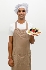 Male chef with cheese plate with grapes, nuts and strawberry