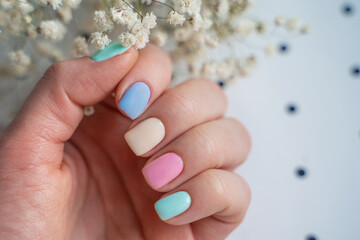 well-groomed, manicured bride fingers in pastel colors of the hand