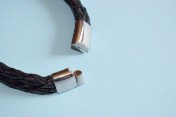 Black leather bracelet with magnetic clasp. Bracelet on a blue background.