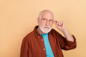 Portrait of mature businessman look empty space touch spectacles brainstorming isolated on beige...