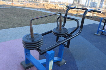 trainers and horizontal bars in city yard