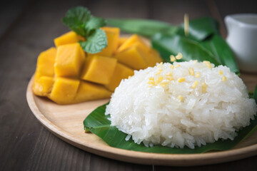 Crispy Mung bean on coconut milk and Flavored Sticky Rice with Ripe Mango on wood dish,