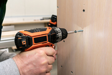 Cordless screwdriver in the hands of a worker