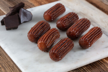 Chocolate Tulumba dessert served on the marble 