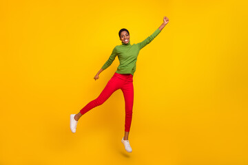 Fototapeta na wymiar Photo of lucky sweet trans woman wear green turtleneck jumping high empty space isolated yellow color background