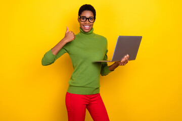 Photo of clever cool trans woman wear green turtleneck working modern device thumb up isolated yellow color background