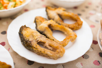 pieces of the middle part of the carp baked on a white plate