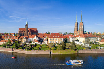 Naklejka premium Poland. Wroclaw. Ostrow Tumski, Gothic cathedral of St. John the Baptist, Collegiate Church of the Holy Cross, tourist ship, boat and Odra (Oder) River. Aerial view at sunset