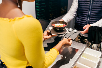 Waitress serving smoothie bowl at cafe counter