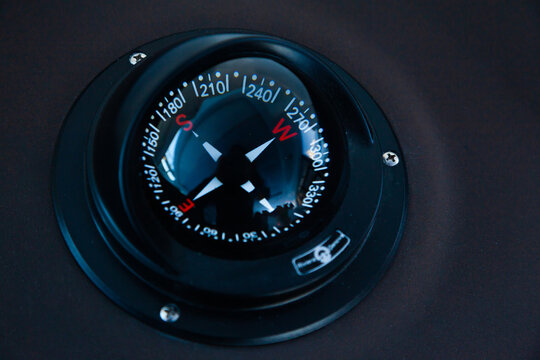 Marine gyrocompass mounted on the black hull of the yacht, close-up. Yacht navigation equipment.