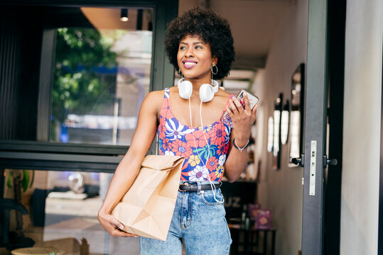 Happy Woman With Paper Bag Leaving Coffee Shop