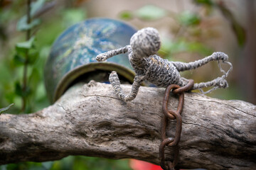 Peculiar hand made decoration crafted and bound on a tree with a chain and a pot