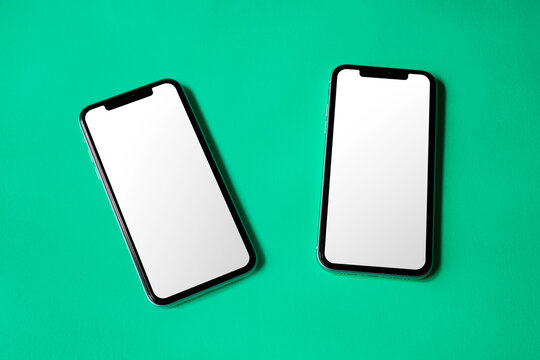 Double smartphone screen mockup above flat paper texture by real photography