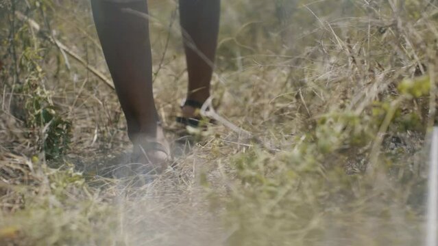 close up feet walking in the field at daytime in slow motion
