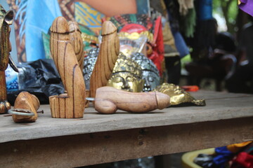 Wooden penises figures souvenir on display for sale to tourists on street local market in Ubud, island Bali, Indonesia. Wooden penises are used in Bali as a remedy against the evil eye and bad spirits