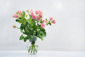 Fototapeta na wymiar bouquet and bouquet pink roses in water in a glass vase isolated on a white background