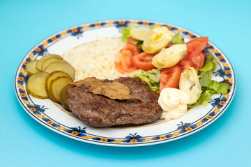 Fried ground meat with fresh salad and boiled rice on white plate