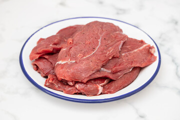 raw fresh meat with pepper on white dish
