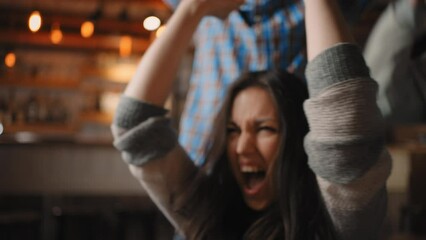 soccer fans watching the match and cheering for their team. Women sitting in the crowd at sports event.