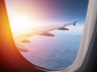 Airplane wing. Air View from plane window on sunset. Travel and transport concept
