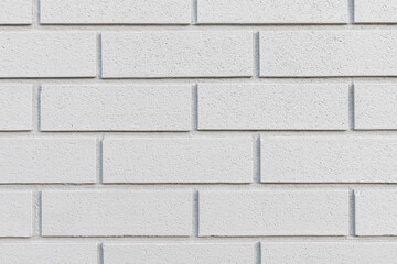 Grey brick painted wall textured background close-up.
