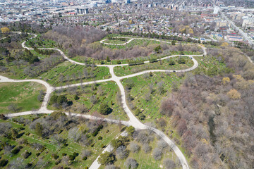 Hover over modern American city cemetery. Many grave stone and stone crosses at city cemetery. Sunny Spring day. Aerial view at burial ground tombs from above.