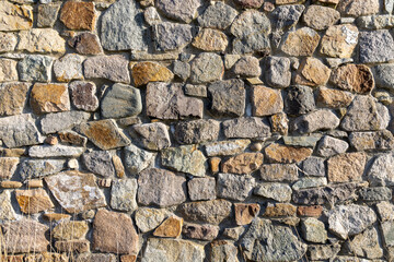 Background from a wall with stones in sunlight