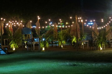 Fototapeta na wymiar Celebration venue decorated with plants and lights at night