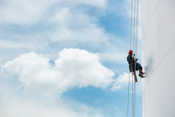 Male workers down height tank rope access inspection of thickness shell plate storage tank.
