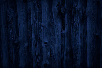 Navy blue wood planks texture. Dark rough wooden fence surface. Close-up. Toned background with...