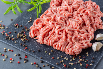 Fresh raw minced pork and spices in a on a cutting board close up 