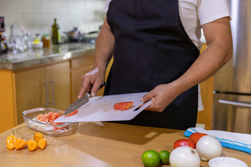 close up of man's hands cutting vegetables.