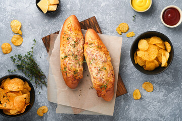 Baguette boats. Hot baked sandwich on baguette bread with ham, bacon, vegetables and cheese on...