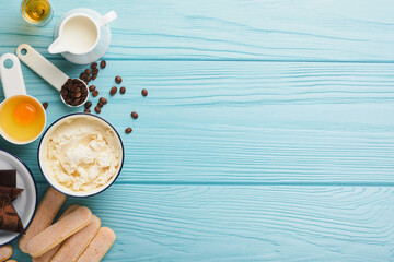 Tiramisu dessert. Ingredients for making dessert tiramisu. Cooking Italian food dessert Tiramisu with all necessary ingredients cocoa, coffee, mascarpone cheese on turquoise wooden background Top view