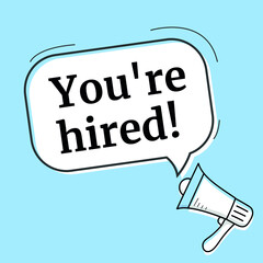 Male hand holding megaphone with you're hired speech bubble. Loudspeaker.