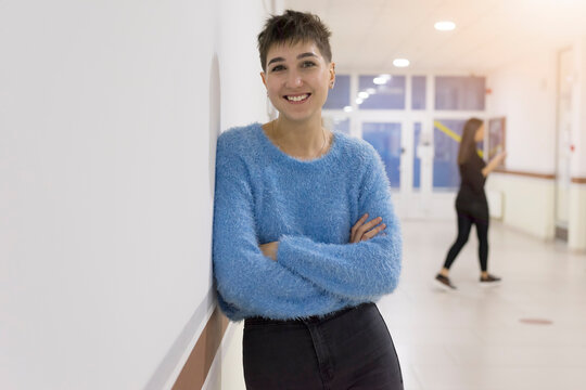 Smiling female student posing inside hall of university