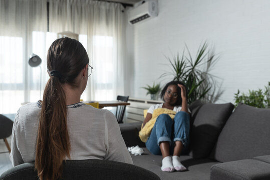 Young African American Woman Telling Her Bad Experience To Psychotherapist After She Was A Crime Victim Of Robbery Attack On The Street. Exchange Student Talking To Therapist About Racism.